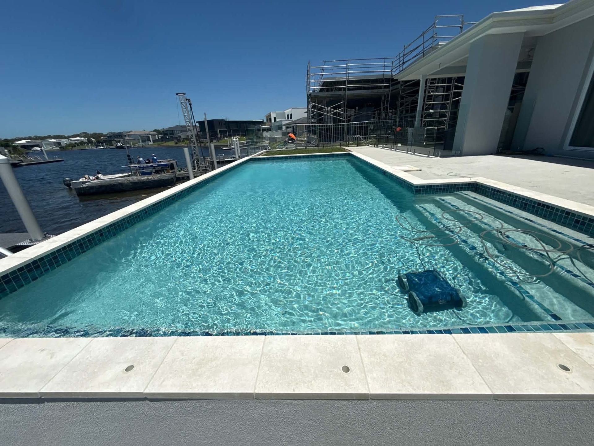 Infinity Pool Beside a Marina Under a Clear Blue Sky — Mad Pool Interiors and Renovations in Baringa, QLD