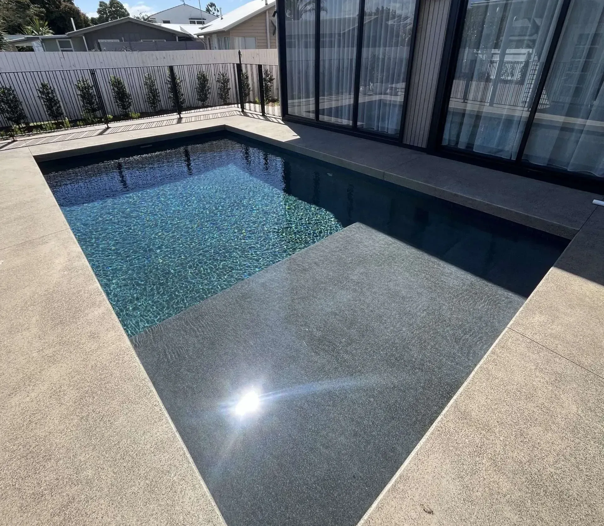 Rectangular Pool With Dark Tile and Gray Steps — Mad Pool Interiors and Renovations in Baringa, QLD