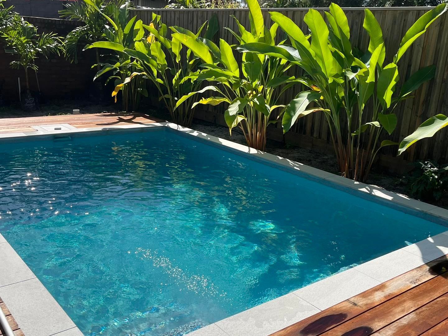 Rectangular Turquoise Pool Surrounded by Light-colored Tiles — Mad Pool Interiors and Renovations in Baringa, QLD
