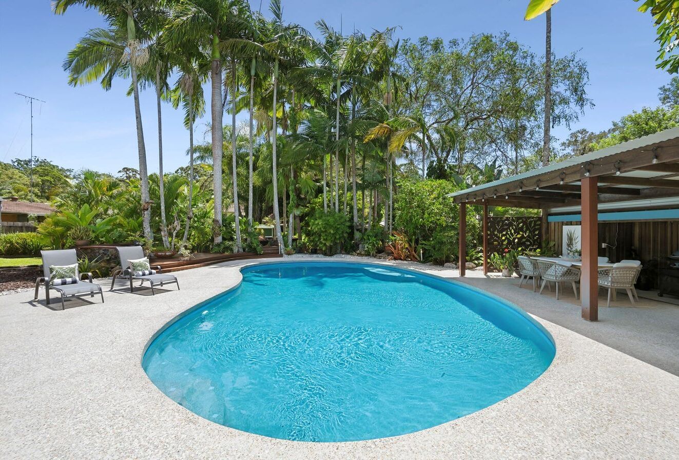 Swimming Pool Surrounded by a White Patio, Trees — Mad Pool Interiors and Renovations in Baringa, QLD