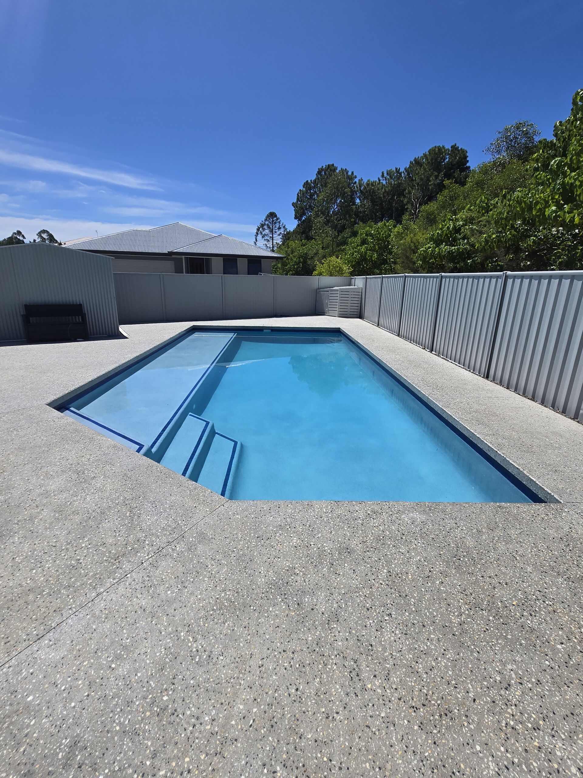 Modern Backyard Pool With Blue Water and Light Gravel Deck — Mad Pool Interiors and Renovations in Baringa, QLD