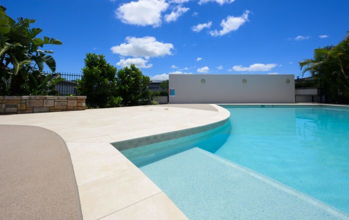 Empty Turquoise Swimming Pool with Curved White Deck — Mad Pool Interiors and Renovations in Baringa, QLD