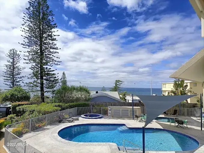 Poolside Patio With Blue Pool and Ocean View — Mad Pool Interiors and Renovations in Baringa, QLD