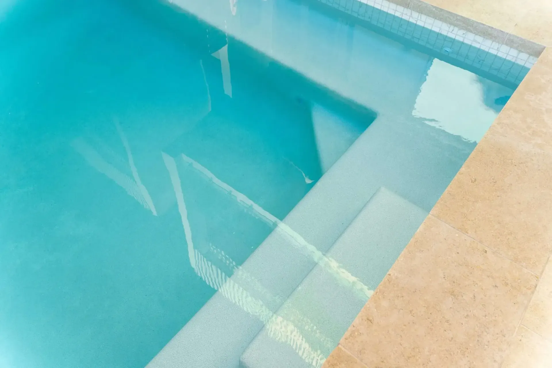 Blue Water Pool With Submerged Steps and Beige Border — Mad Pool Interiors and Renovations in Baringa, QLD