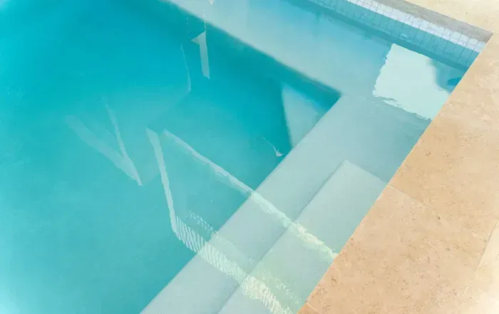 Swimming Pool Steps with Clear Turquoise Water — Mad Pool Interiors and Renovations in Baringa, QLD