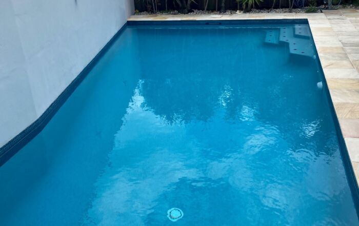 Small Blue Swimming Pool with Clear Water Beside a Light-Colored Wall — Mad Pool Interiors and Renovations in Baringa, QLD