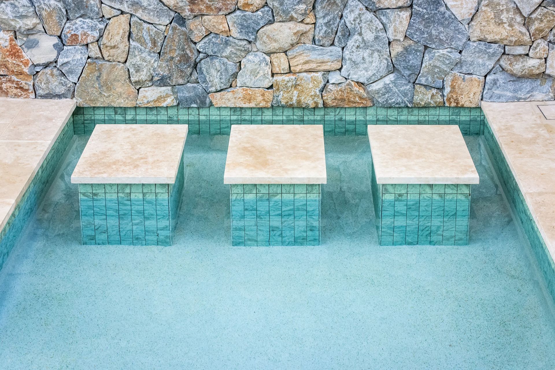 Three Submerged Pool Stools With Beige Tops and Turquoise Tiled Bases — Mad Pool Interiors and Renovations in Baringa, QLD