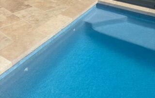Blue Swimming Pool Corner Beside Beige Tiled Deck — Mad Pool Interiors and Renovations in Baringa, QLD