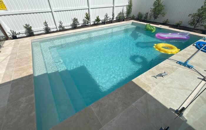 Backyard Swimming Pool with Clear Blue Water — Mad Pool Interiors and Renovations in Baringa, QLD