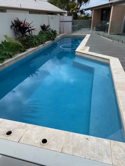 Outdoor Swimming Pool With Blue Water and White Stone Edging — Mad Pool Interiors and Renovations in Baringa, QLD