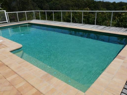 Rectangular Turquoise Swimming Pool With Tan Tile Deck — Mad Pool Interiors and Renovations in Baringa, QLD