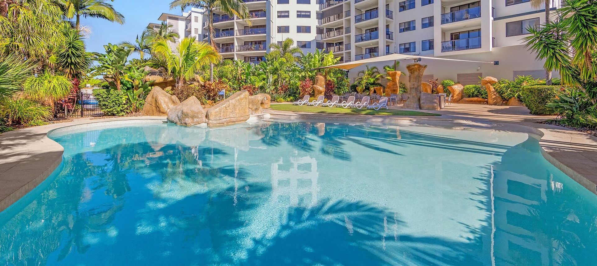 Swimming Pool in Front of a Modern Building — Mad Pool Interiors and Renovations in Baringa, QLD