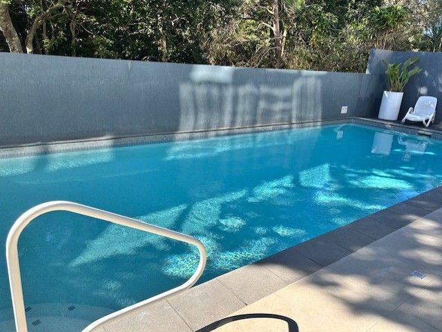 Swimming Pool With Blue Water and Handrail — Mad Pool Interiors and Renovations in Baringa, QLD