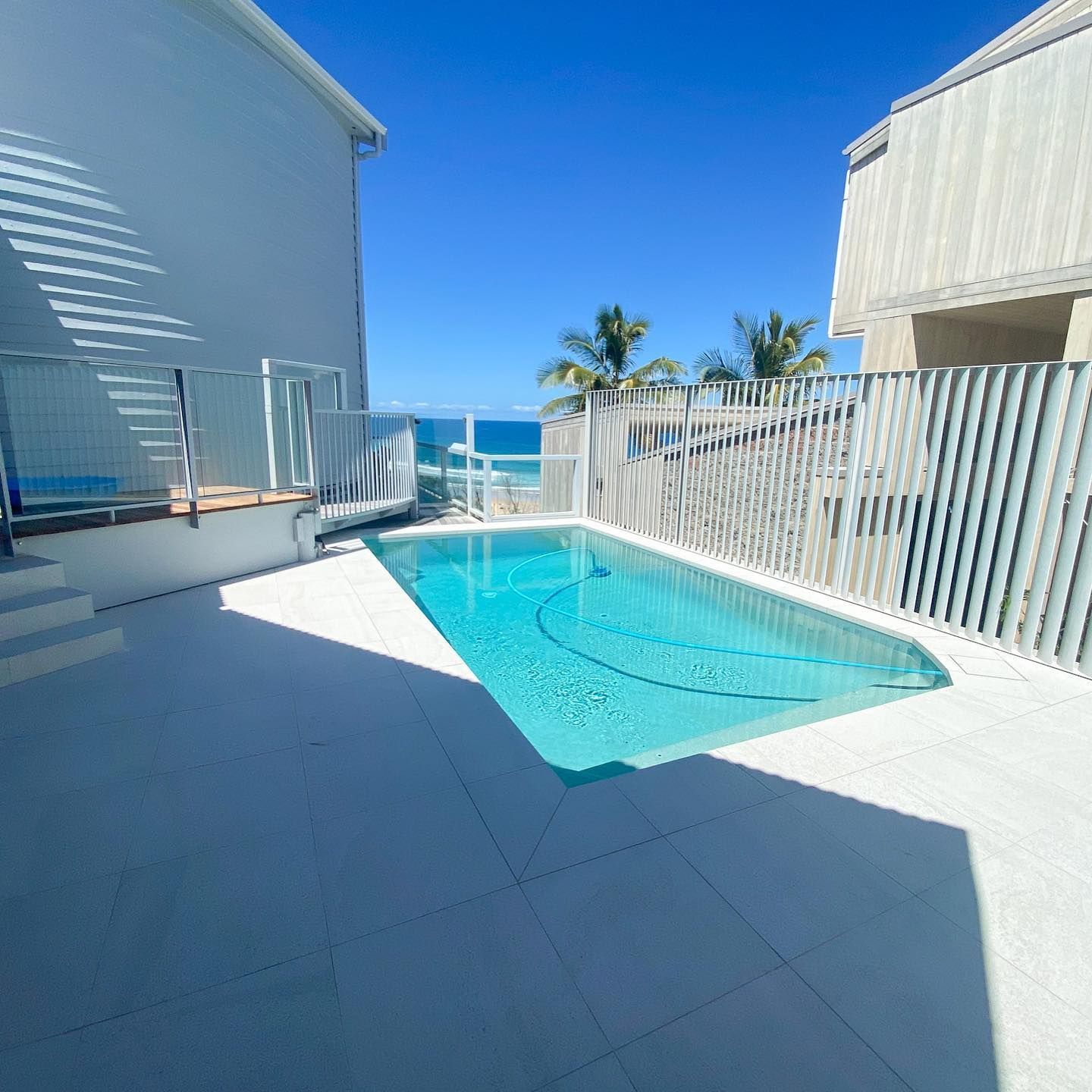 Small Outdoor Pool Beside White Buildings — Mad Pool Interiors and Renovations in Baringa, QLD