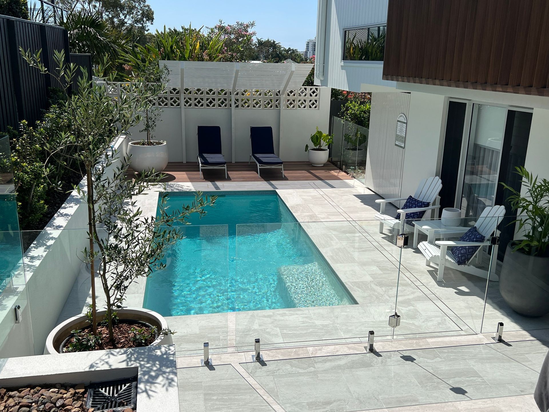 Pool Area With a Small Rectangular Pool, Lounge Chairs — Mad Pool Interiors and Renovations in Baringa, QLD