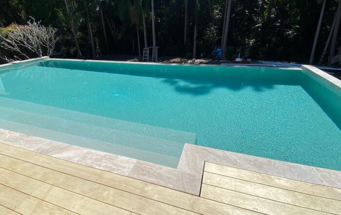 Turquoise Swimming Pool with Pale Wood Deck — Mad Pool Interiors and Renovations in Baringa, QLD