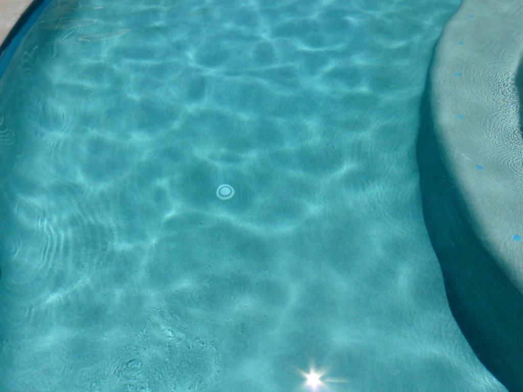 Turquoise Swimming Pool Water With Sunlight Reflections — Mad Pool Interiors and Renovations in Baringa, QLD