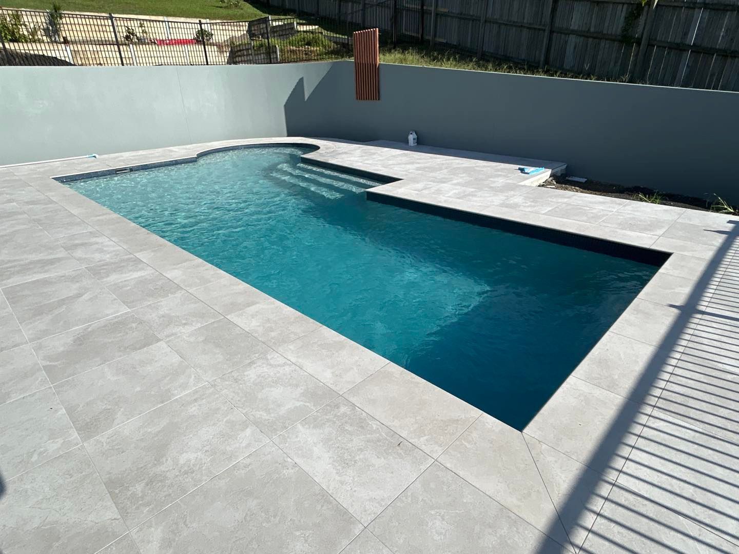 Swimming Pool With Turquoise Water And Privacy Walls — Mad Pool Interiors and Renovations in Baringa, QLD