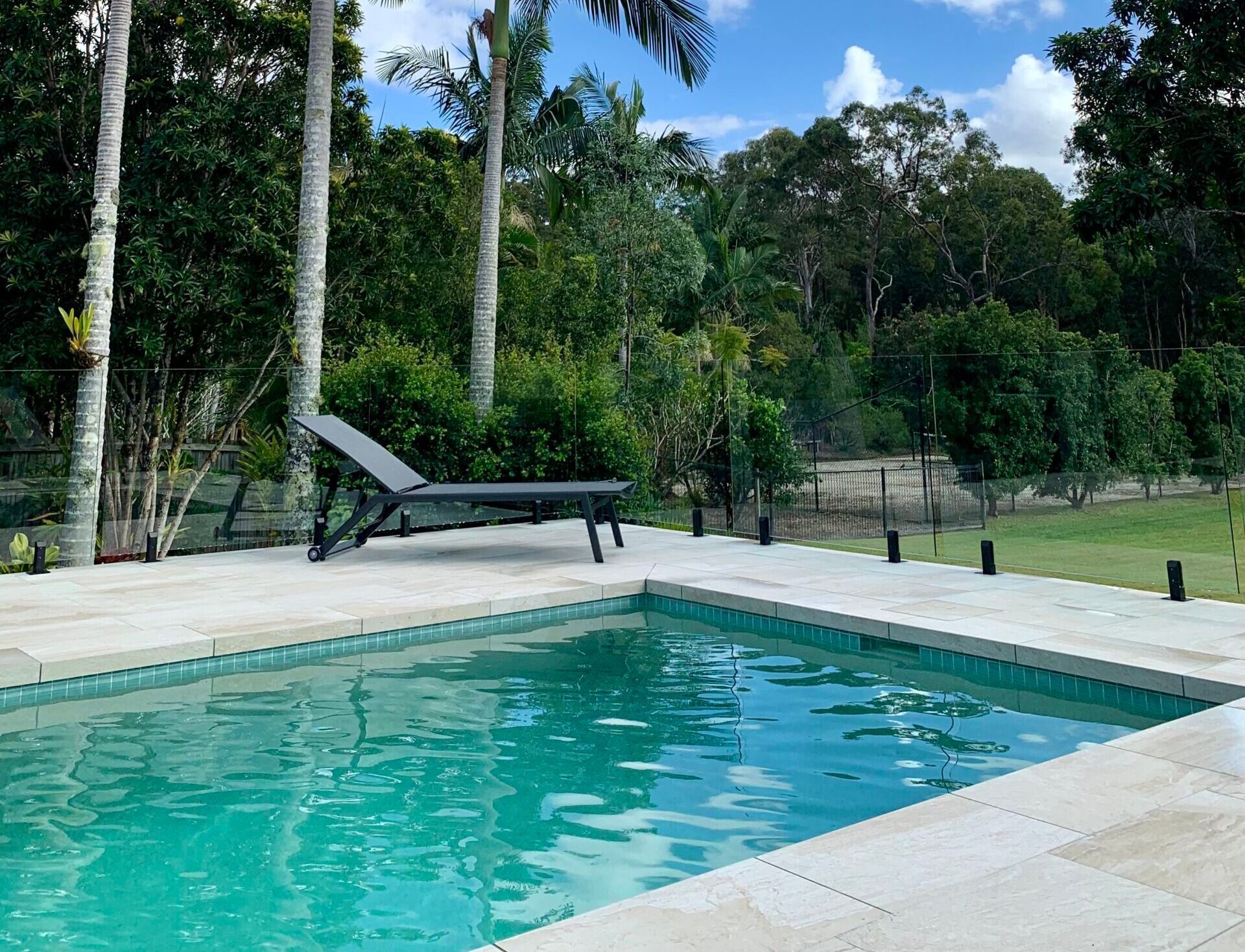 Pool With a Lounge Chair on the Deck — Mad Pool Interiors and Renovations in Baringa, QLD