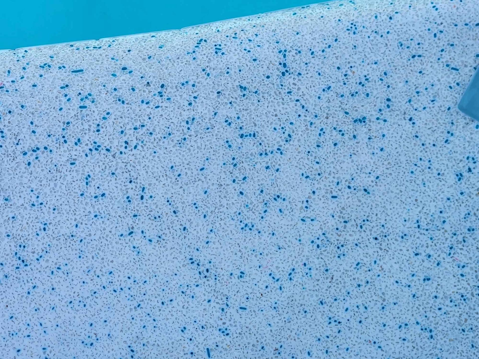 Close-up of a Pool's Light-blue, Speckled Surface With Blue-green Water — Mad Pool Interiors and Renovations in Baringa, QLD