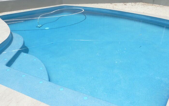 Blue Swimming Pool with Clear Water and A White Pool Ledge — Mad Pool Interiors and Renovations in Baringa, QLD