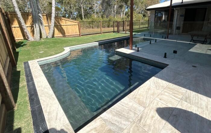 Backyard Swimming Pool with A Raised Patio and Lounge Area — Mad Pool Interiors and Renovations in Baringa, QLD