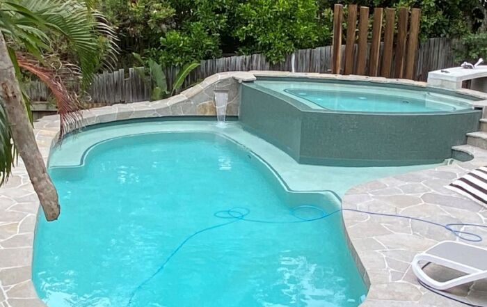 Tropical Backyard Pool with Turquoise Water — Mad Pool Interiors and Renovations in Baringa, QLD