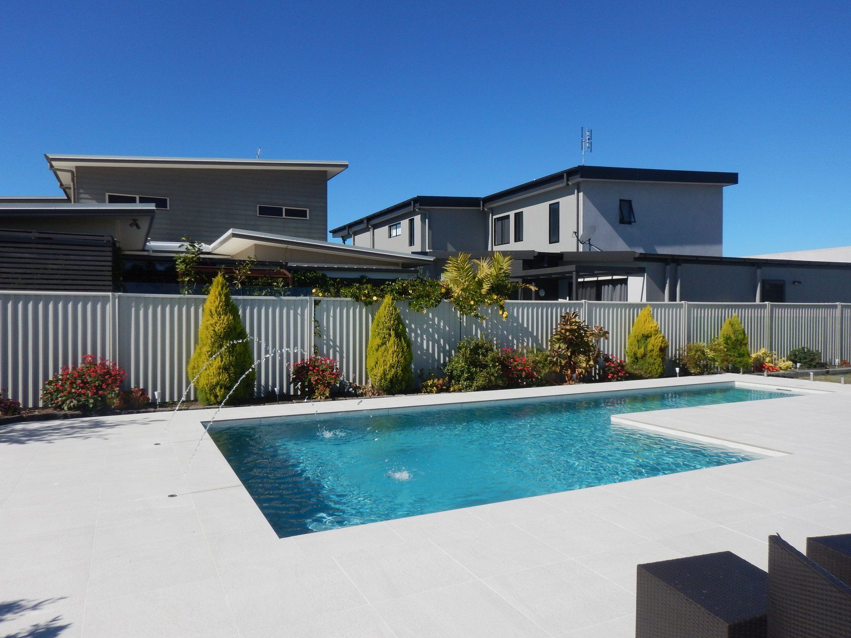 Modern Backyard With a Turquoise Pool and White Patio — Mad Pool Interiors and Renovations in Baringa, QLD
