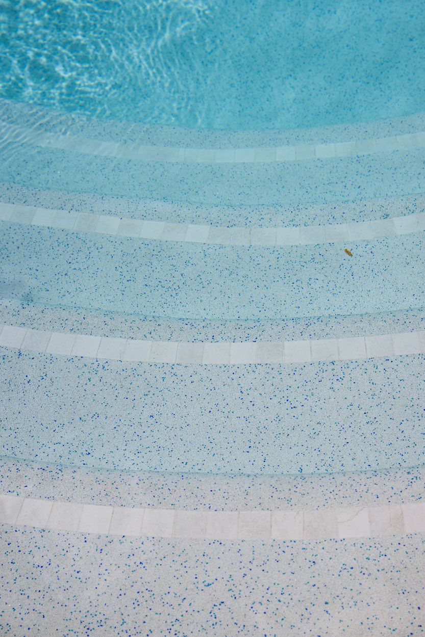 Steps Leading Down Into a Swimming Pool With Clear, Blue Water — Mad Pool Interiors and Renovations in Baringa, QLD
