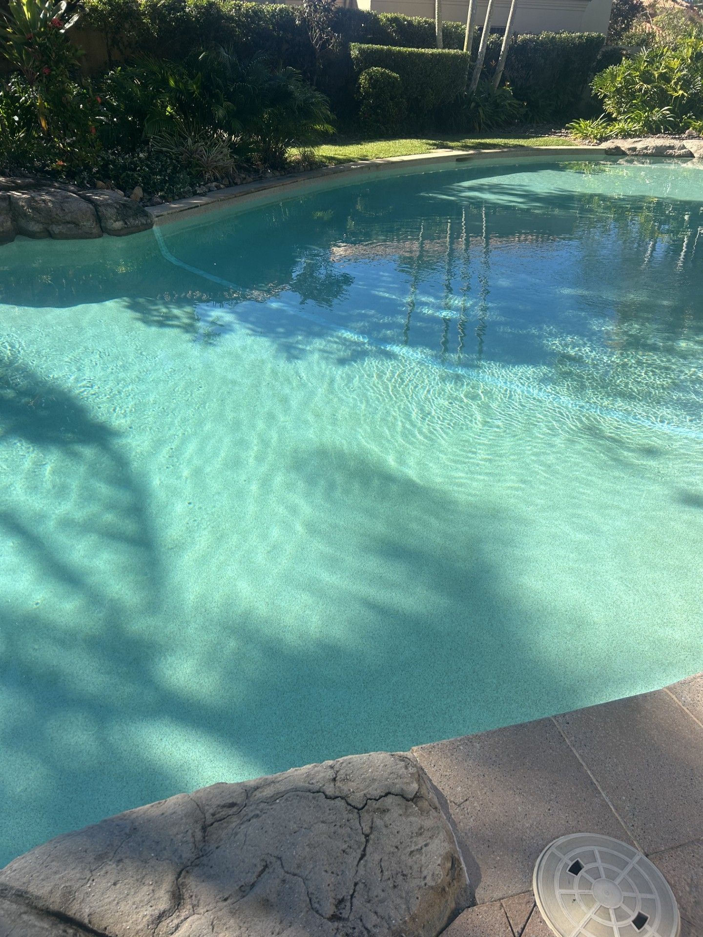 A Light Blue Swimming Pool With Clear Water Reflecting the Sky — Mad Pool Interiors and Renovations in Baringa, QLD