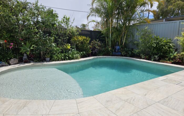 Backyard Swimming Pool with Pale Blue Water — Mad Pool Interiors and Renovations in Baringa, QLD