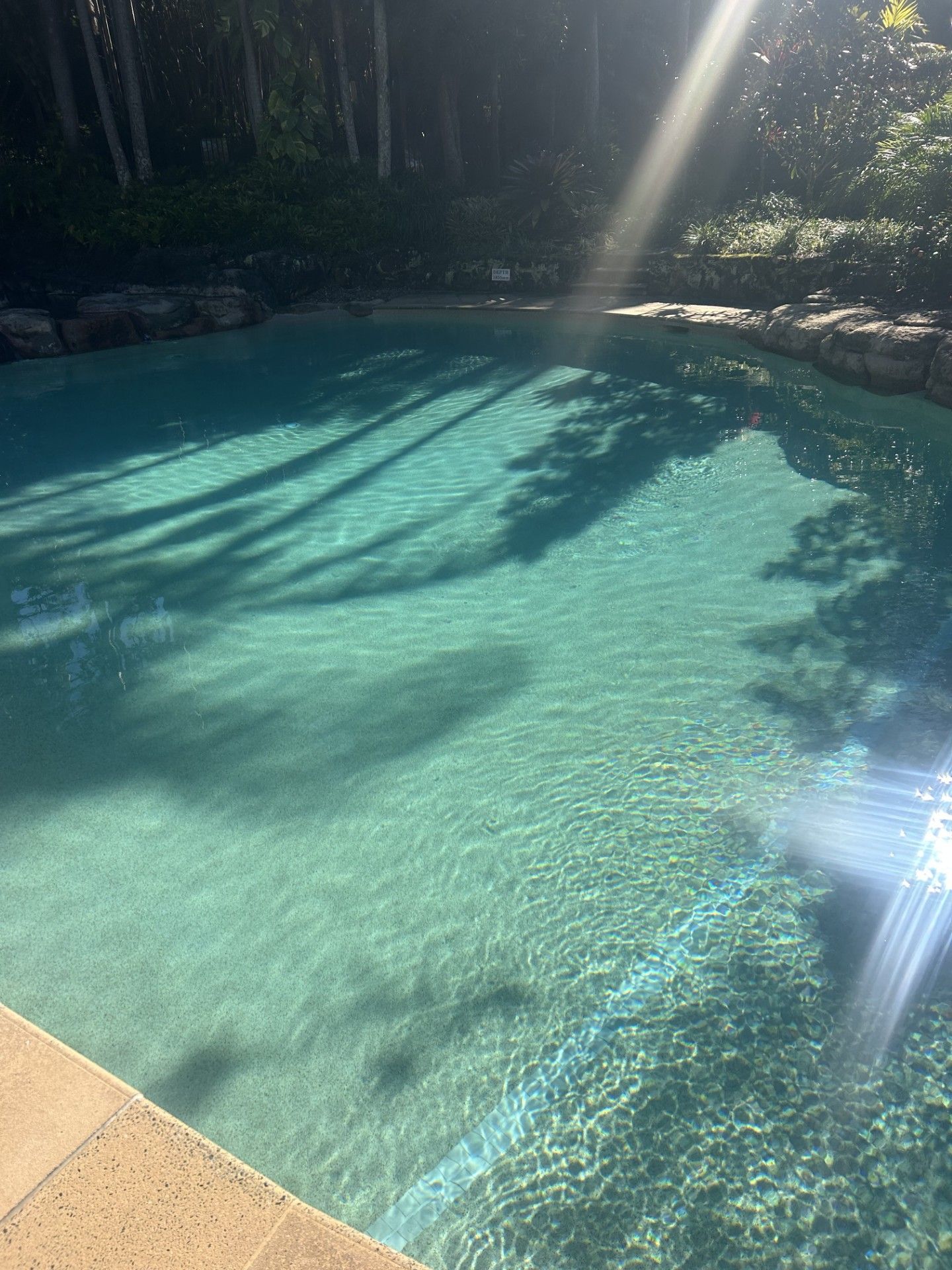 Pool With Turquoise Water Reflecting Sunlight — Mad Pool Interiors and Renovations in Baringa, QLD