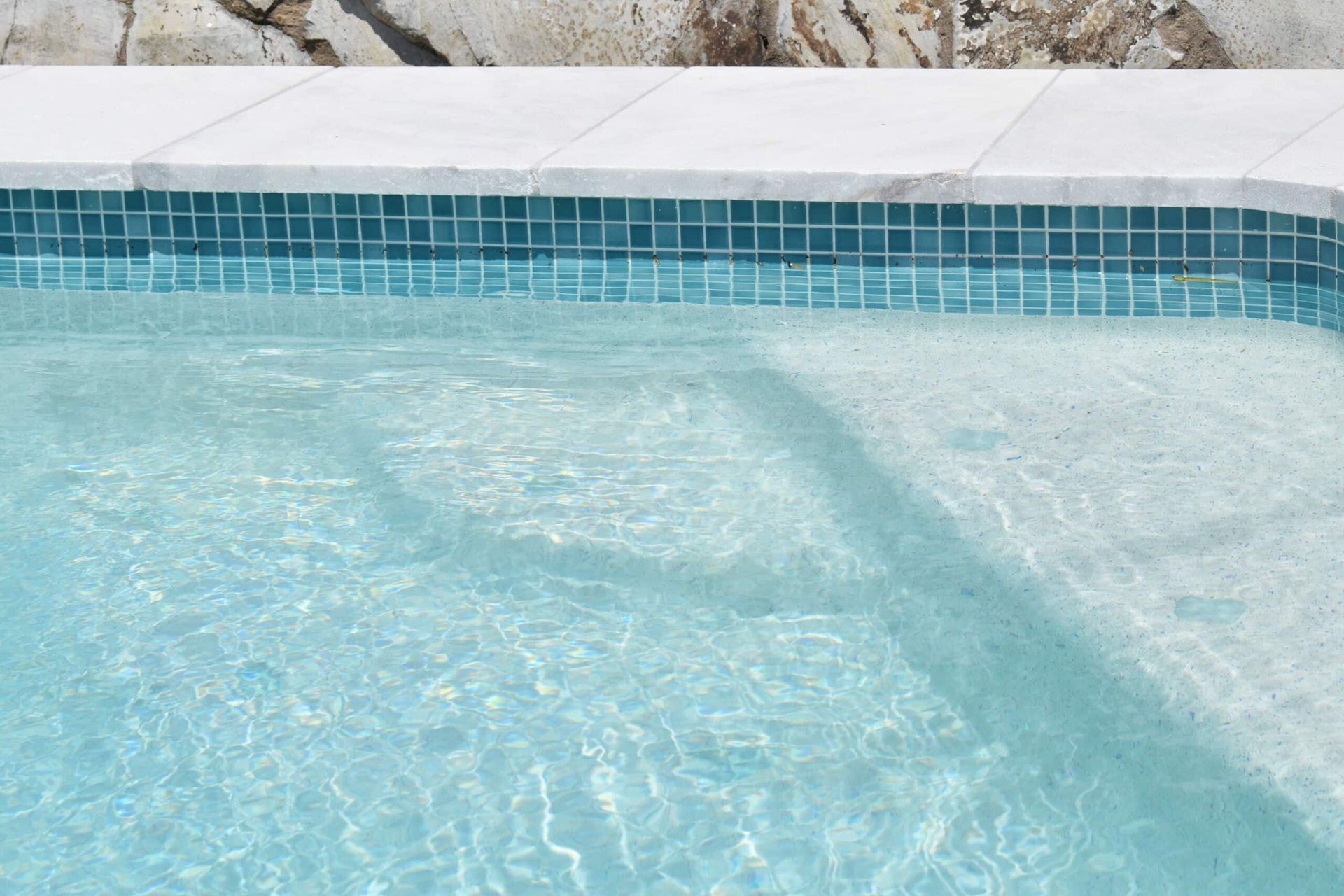 Pool With Blue Tiled Edge and Steps, Clear Water Reflecting Sunlight — Mad Pool Interiors and Renovations in Baringa, QLD