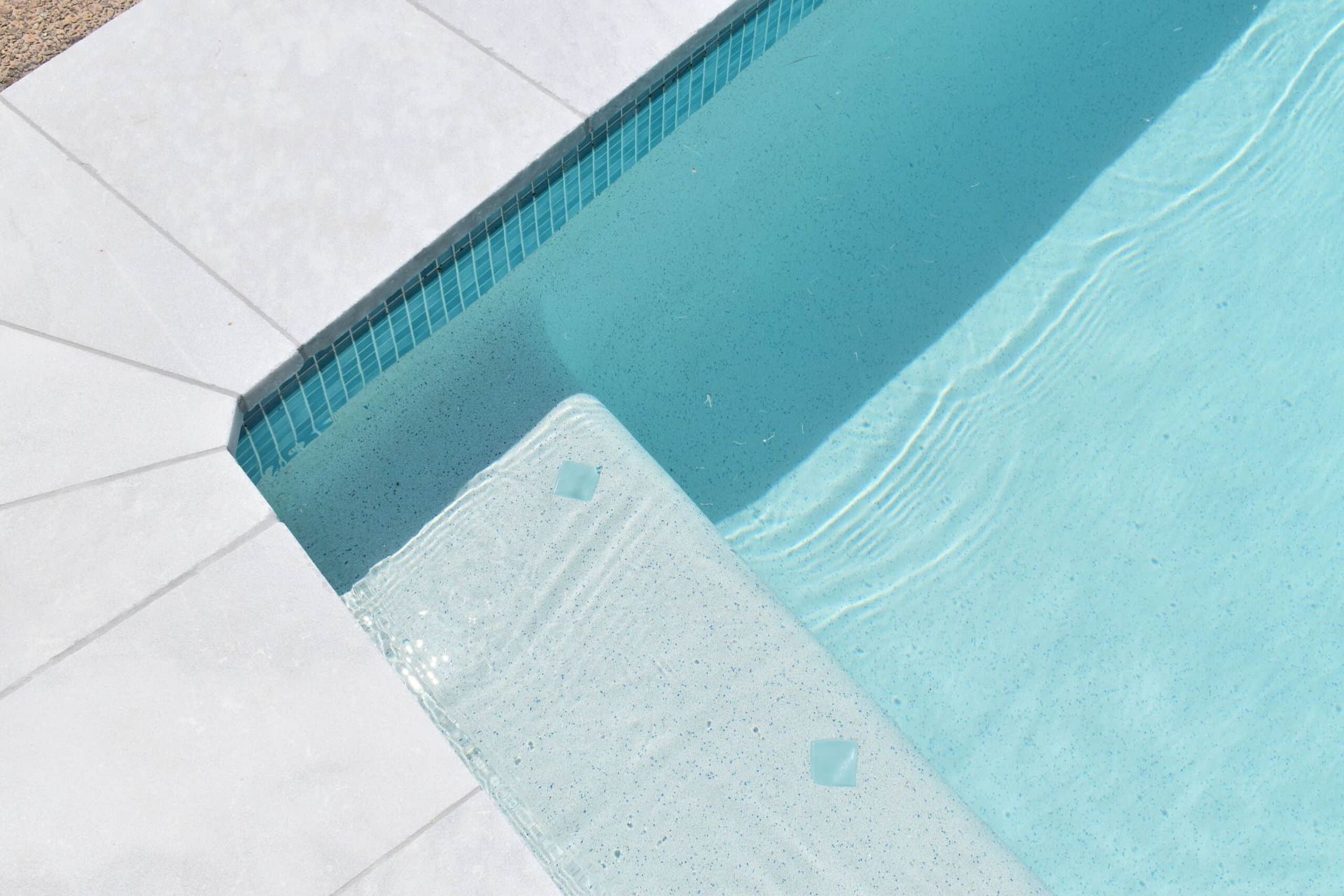 Pool With White Tiled Deck and Light Blue Water — Mad Pool Interiors and Renovations in Baringa, QLD