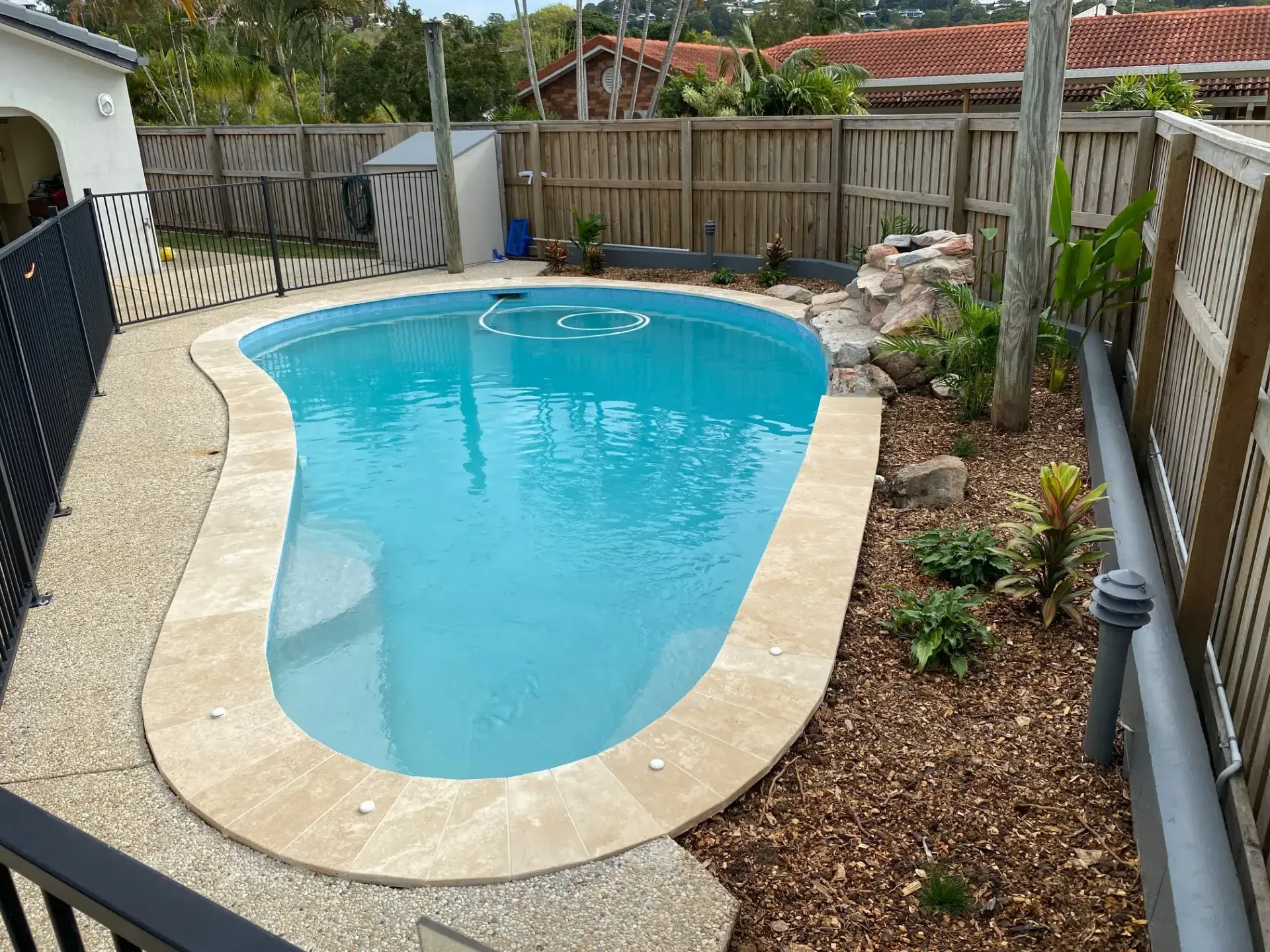 Small Backyard Swimming Pool With Blue Water — Mad Pool Interiors and Renovations in Baringa, QLD