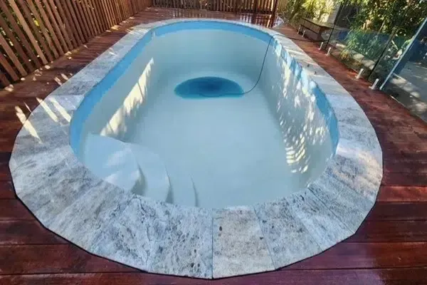 Small White Backyard Hot Tub With a Blue Seat Area — Mad Pool Interiors and Renovations in Baringa, QLD