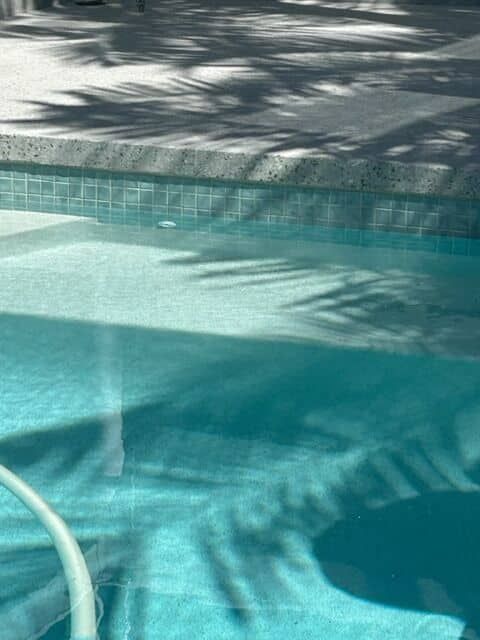 A Blue Swimming Pool With Shadow Patterns — Mad Pool Interiors and Renovations in Baringa, QLD