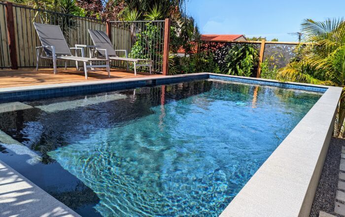 Modern Backyard Swimming Pool with Lounge Chairs — Mad Pool Interiors and Renovations in Baringa, QLD