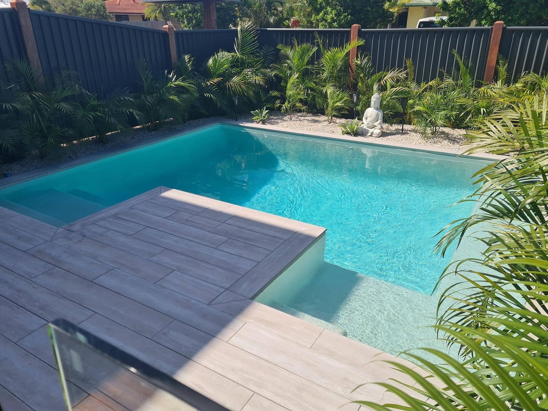 Swimming Pool With Wooden Deck, Steps, and Tropical Plants — Mad Pool Interiors and Renovations in Baringa, QLD