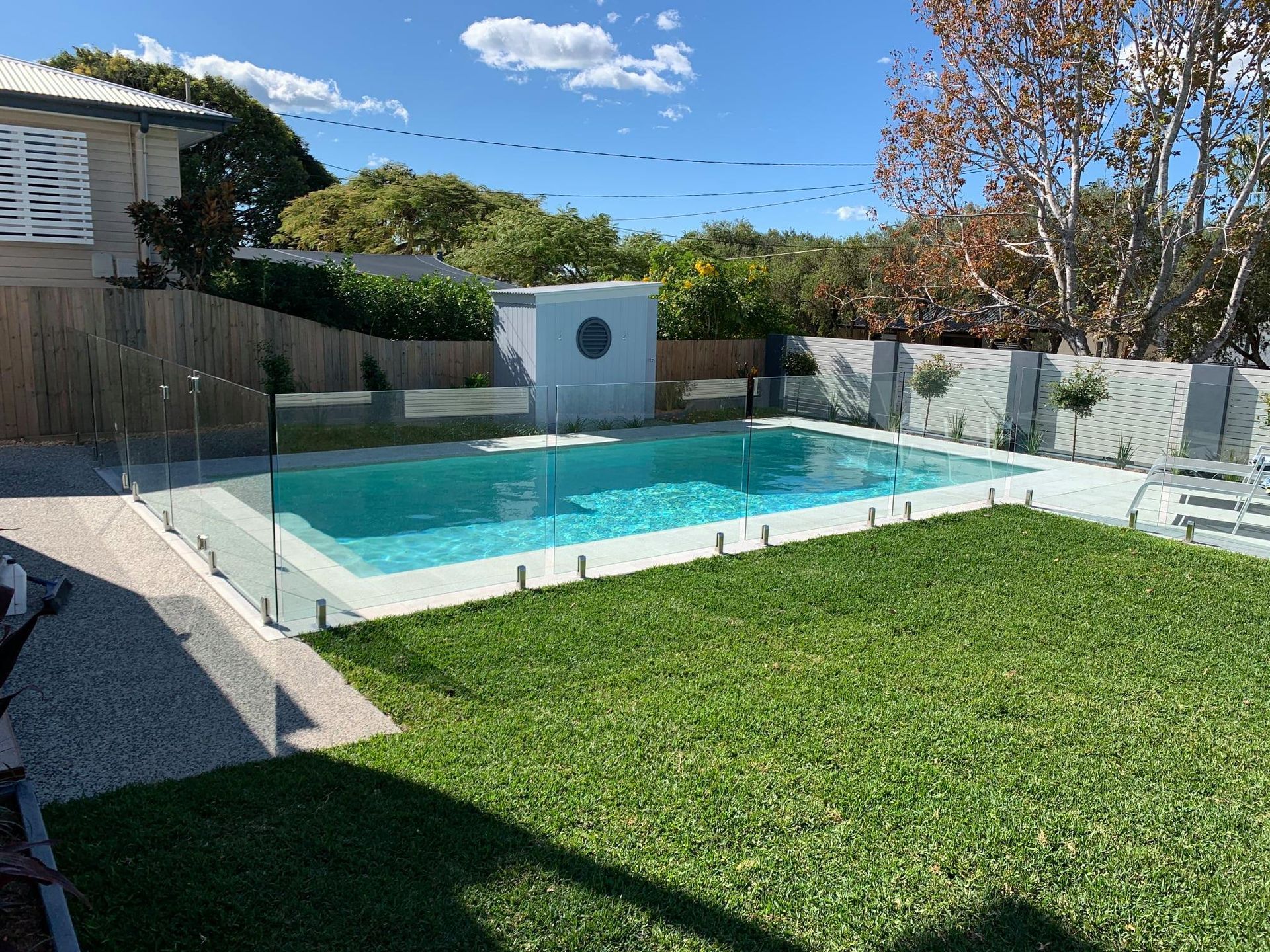A Backyard With a Rectangular Swimming Pool — Mad Pool Interiors and Renovations in Baringa, QLD