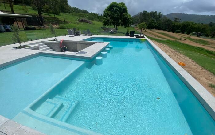 Large Turquoise Swimming Pool with A Shallow Ledge — Mad Pool Interiors and Renovations in Baringa, QLD