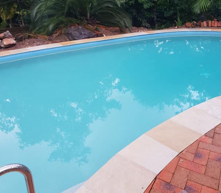 Curved Outdoor Swimming Pool With Turquoise Water — Mad Pool Interiors and Renovations in Baringa, QLD