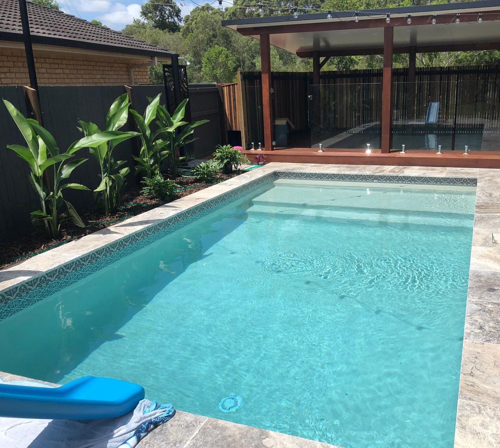 Pool With Blue Water and Steps, Next to Landscaping — Mad Pool Interiors and Renovations in Baringa, QLD