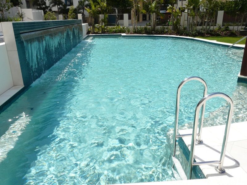 A Rectangular Swimming Pool With a Waterfall Feature — Mad Pool Interiors and Renovations in Baringa, QLD