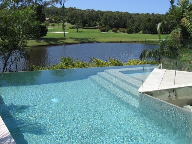 Swimming Pool Overlooking a Lake and Golf Course on a Sunny Day — Mad Pool Interiors and Renovations in Baringa, QLD