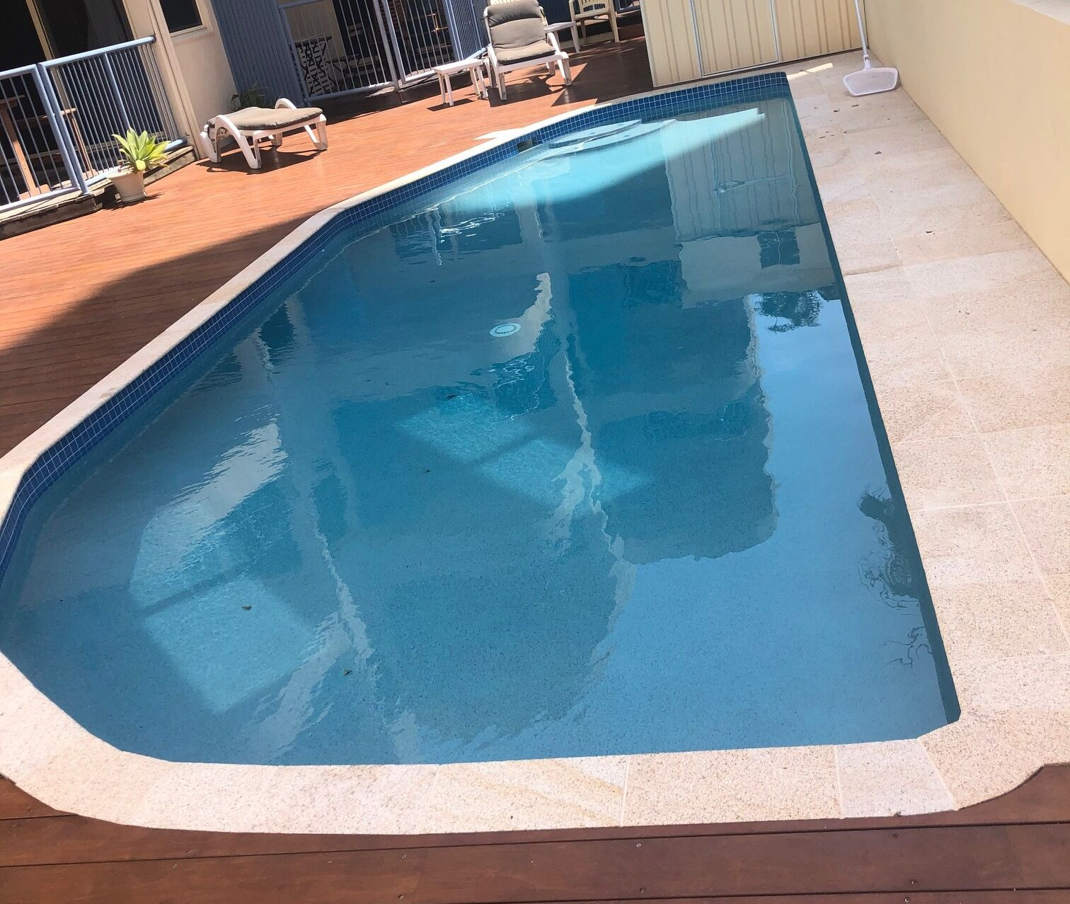 Backyard Swimming Pool With Blue Water and White Coping — Mad Pool Interiors and Renovations in Baringa, QLD