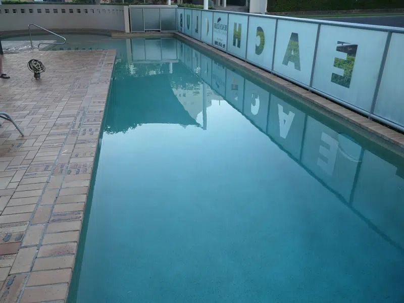 A Long Outdoor Swimming Pool Beside Tiled Deck — Mad Pool Interiors and Renovations in Baringa, QLD