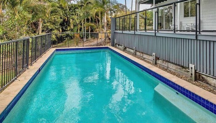 Rectangular Turquoise Swimming Pool Beside a Fenced Deck — Mad Pool Interiors and Renovations in Baringa, QLD