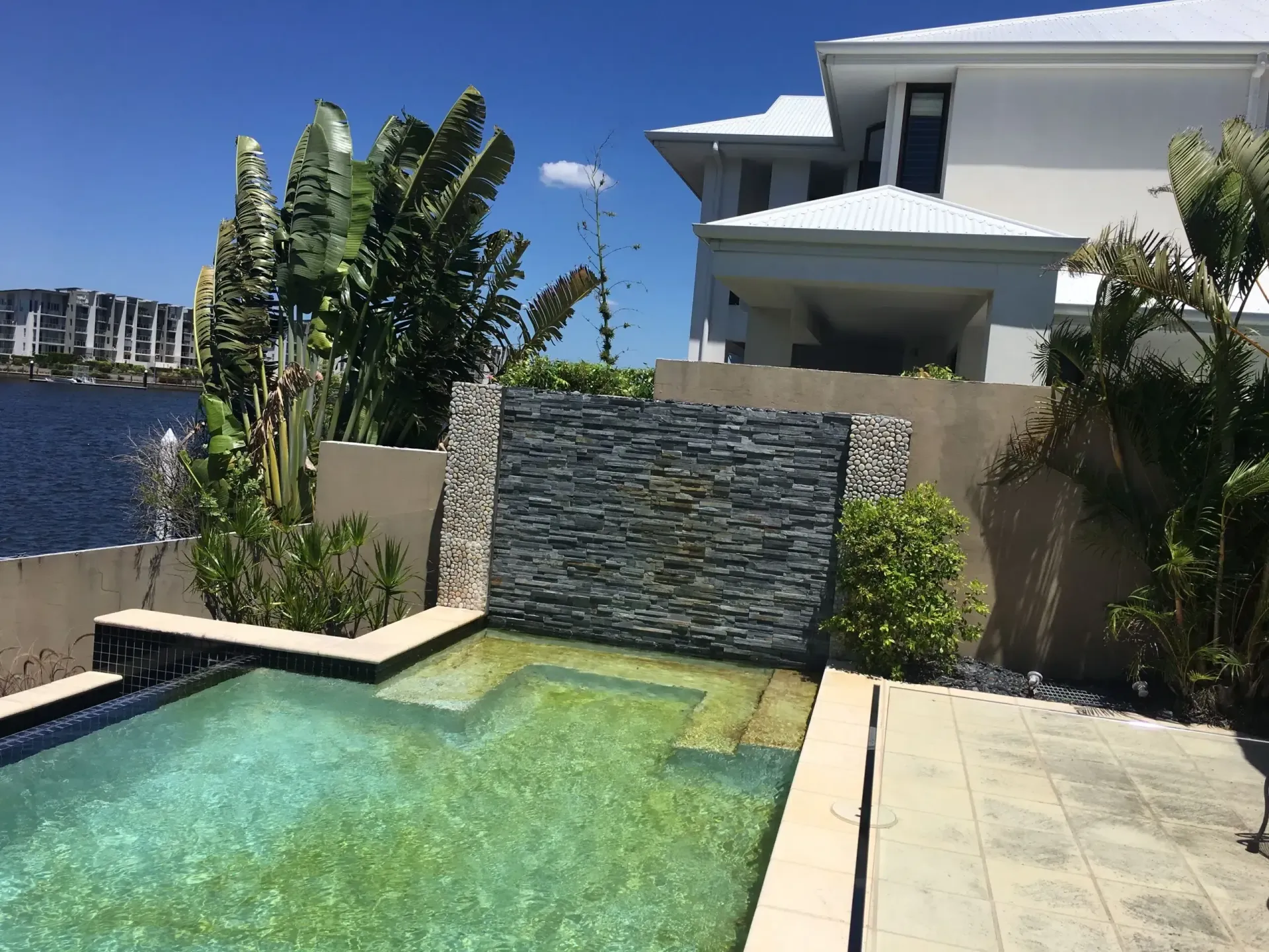 Modern Backyard Pool and Waterfall — Mad Pool Interiors and Renovations in Baringa, QLD