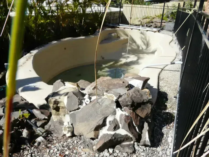 Damaged Backyard Pool With Broken Concrete and Rubble — Mad Pool Interiors and Renovations in Baringa, QLD